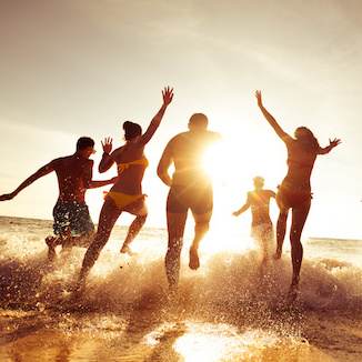 Big company of friends having fun at sunset beach
