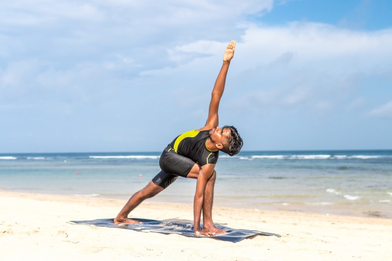 man-doing-yoga-pose-on-blue-mat-beside-seashore-616996